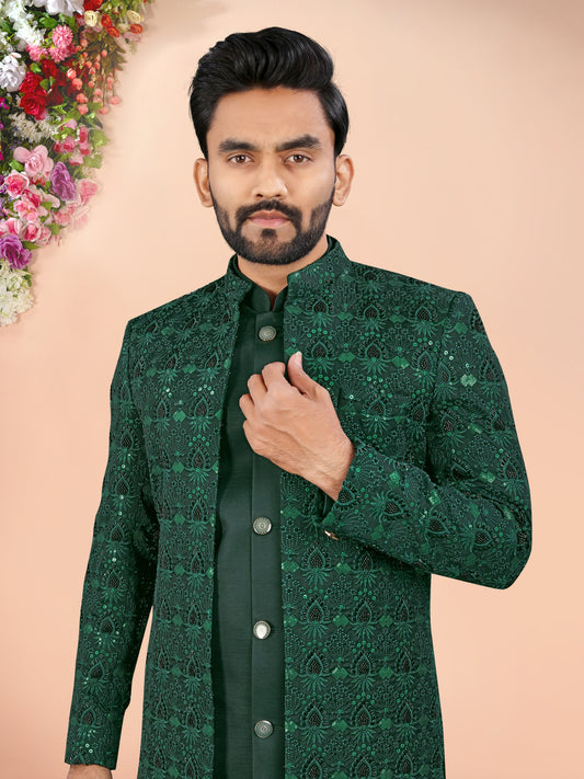 Man wearing a green patterned jacket against a beige background with floral decorations.