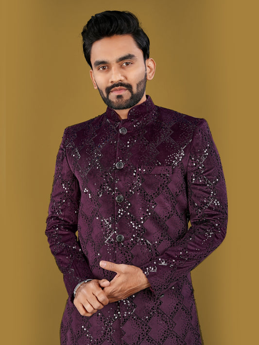 Man wearing a purple sherwani against a gold background
