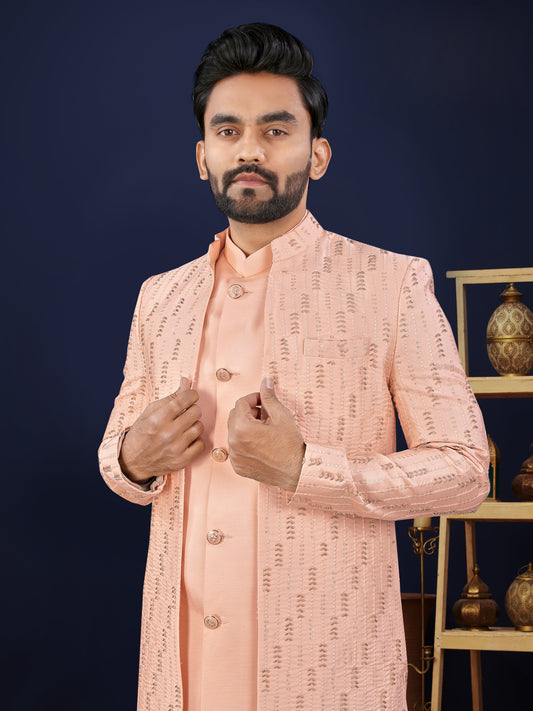Man wearing a peach traditional outfit against a dark background