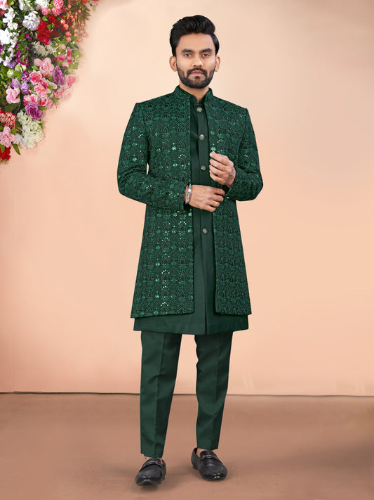 Man wearing a green traditional outfit with a floral background