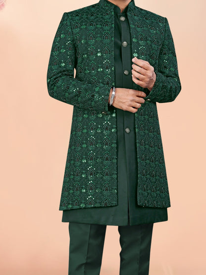 Man wearing a green traditional outfit with a floral background