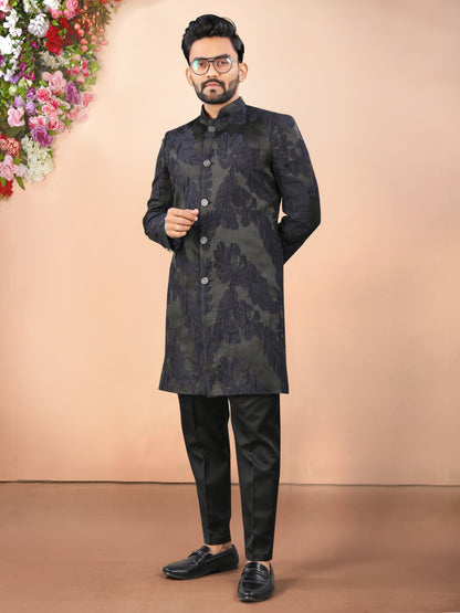 Man wearing black Indian  traditional outfit with a floral arrangement on a beige background