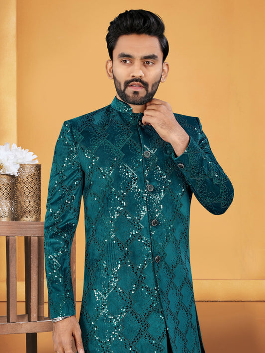 Man wearing a green sequined sherwani against a yellow background
