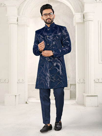 Man wearing a blue sherwani in an elegant white interior setting