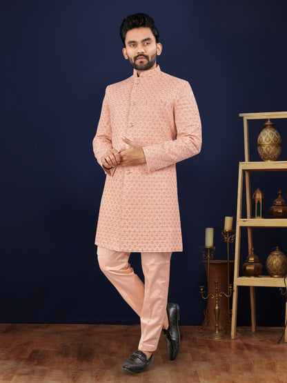 Man wearing a pink traditional outfit against a dark blue background