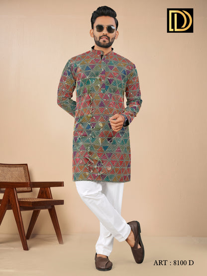 Man wearing a colorful patterned kurta with white pants against a beige background