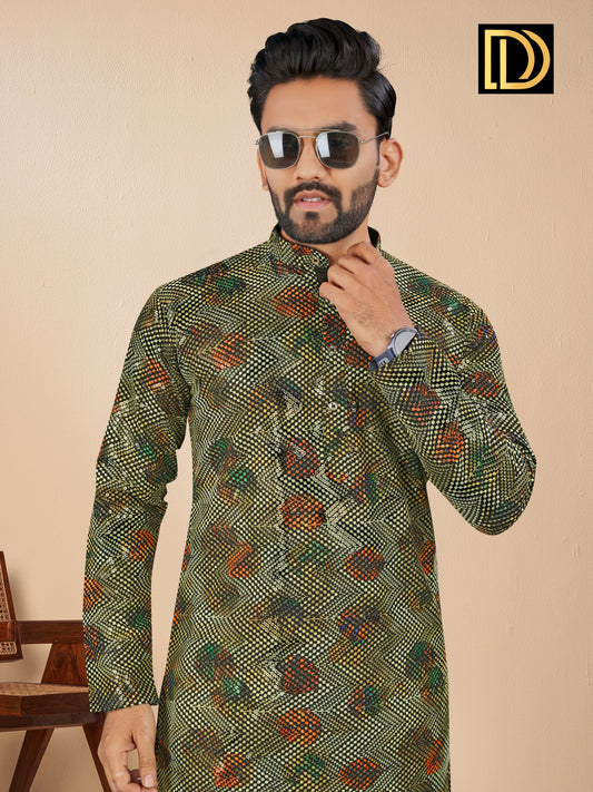 Man wearing a patterned green kurta with sunglasses and a watch, against a beige background.